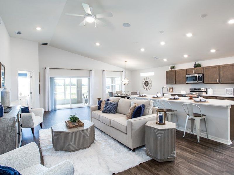 The welcoming, open living area includes volume ceilings and luxury vinyl plank flooring.