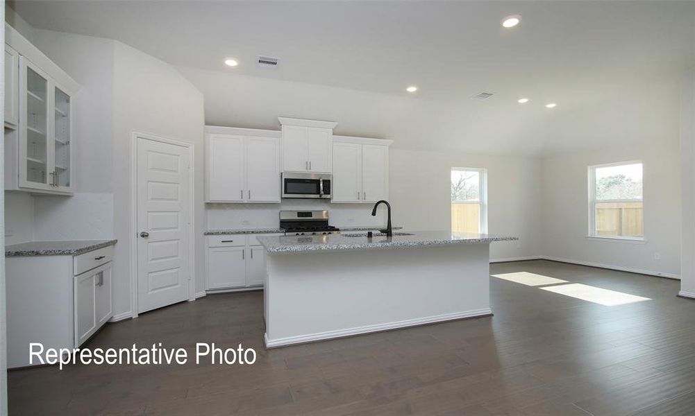 Kitchen with appliances with stainless steel finishes, dark wood-type flooring, and white cabinetry