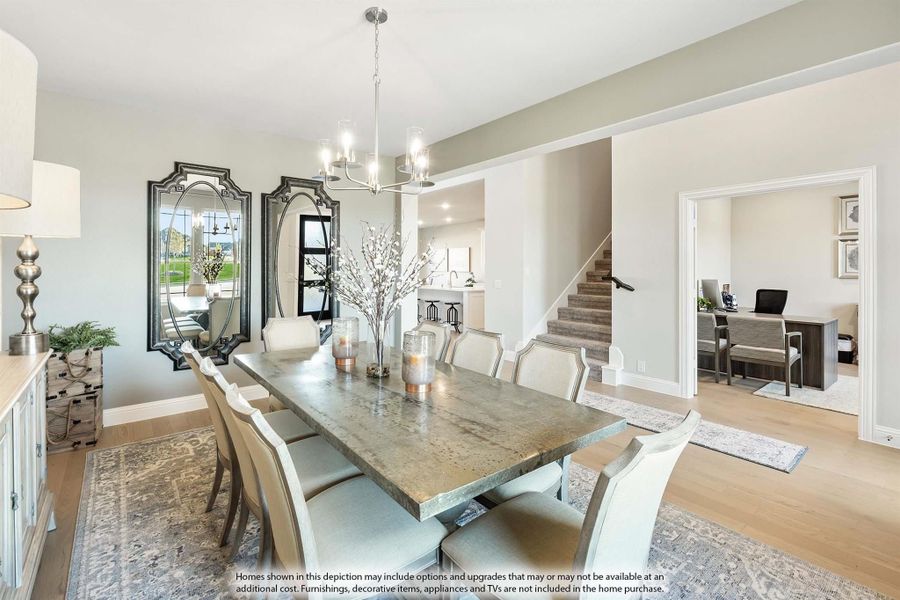 Dining room with large metal table, eight chairs, chandelier, and decorative mirrors on the wall