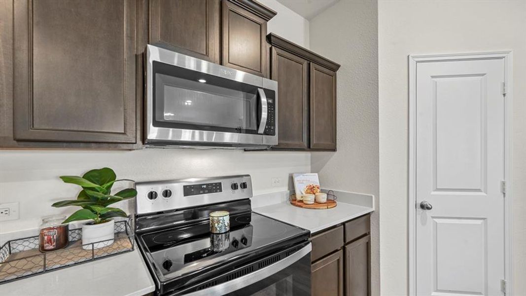 Kitchen featuring stainless steel appliances and dark wood finish cabinetry