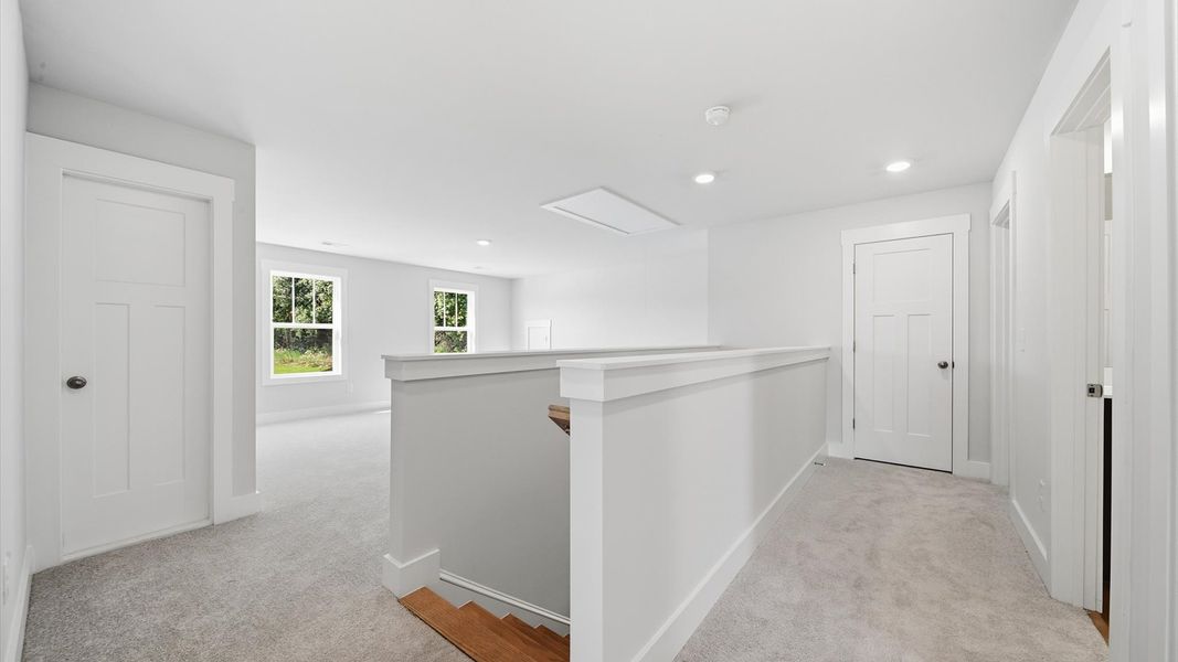 Stylish loft retreat with carpeted flooring and accomplished architectural detail by DRB Homes