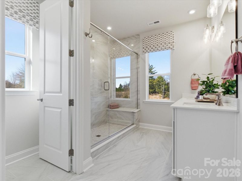 Primary Bathroom with tiled walk-in shower with built-in seat