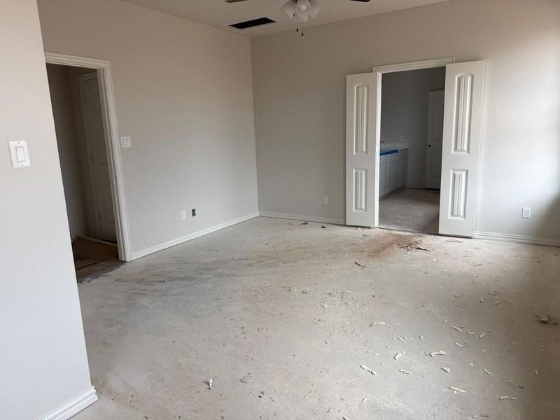 Spacious interior room featuring light gray painted walls and white baseboards