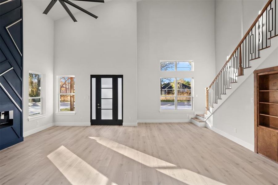 Foyer with a towering ceiling and light wood-type flooring