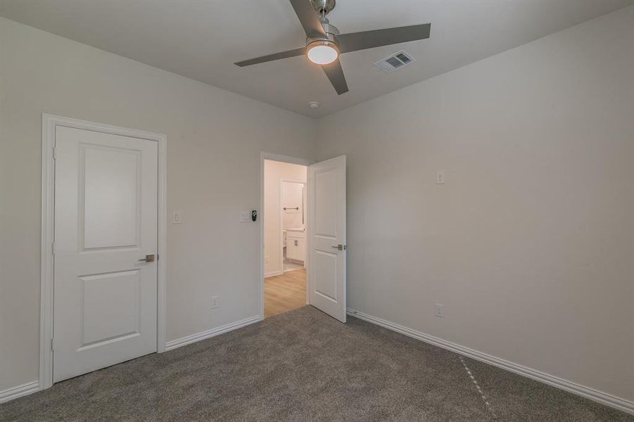 Unfurnished bedroom with ceiling fan and carpet floors