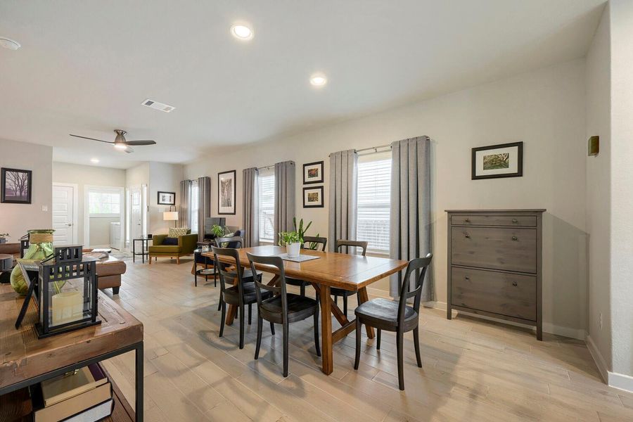 An open-concept living and dining area features abundant natural illumination and polished light hardwood flooring. An open-concept living and dining area features abundant natural illumination and polished light hardwood flooring.