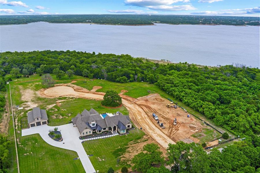 Expansive property featuring a waterfront setting, mature trees, substantial land area, a large main residence with a pool, and a detached three-car garage Expansive property featuring a waterfront setting, mature trees, substantial land area, a large main residence with a pool, and a detached three-car garage