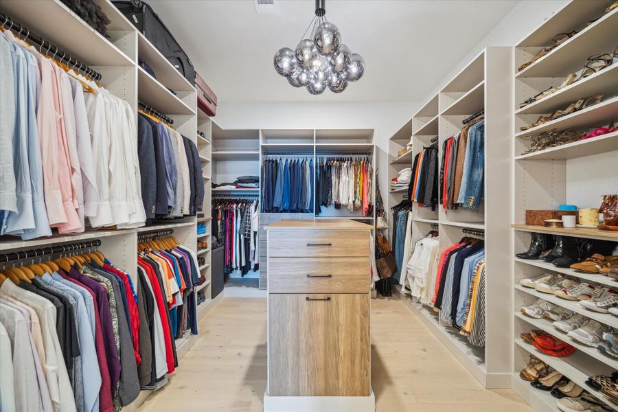 Primary closet custom designed and installed by The Container Store.  Adjustable shelves to fit your needs.