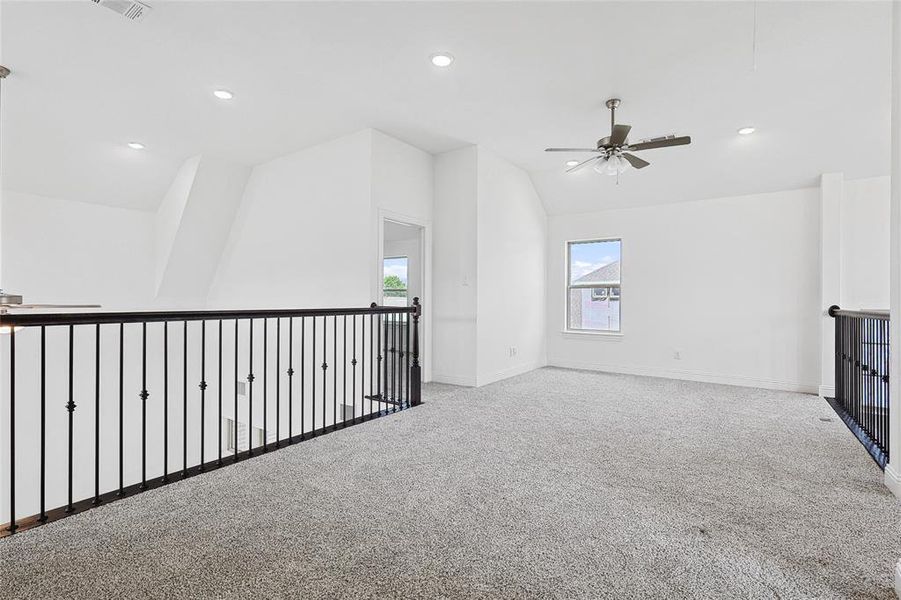 Bonus room featuring ceiling fan, vaulted ceiling, and carpet