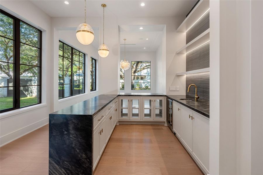 WOW! Entertainment at its best! Spacious bar and serving area. NOTE: This photo is a rendering of one of the builder’s prior homes and similarly used as an example for this home. Please contact the listing agent to tour this property and for more detailed information.