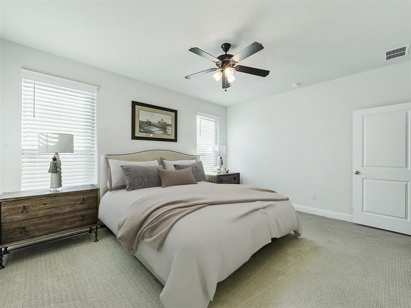 Carpeted bedroom featuring ceiling fan