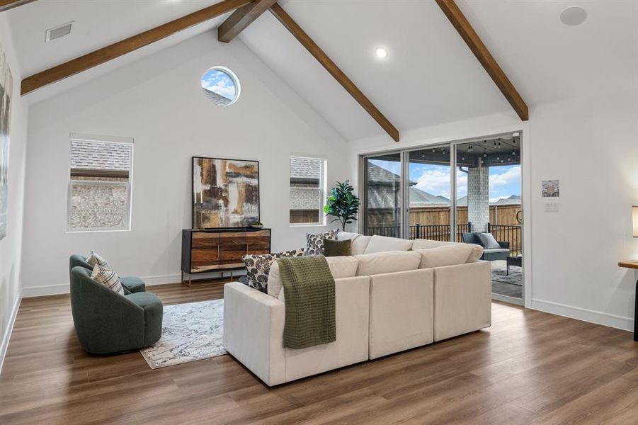 Living area featuring wood finished floors, high vaulted ceiling, and beamed ceiling
