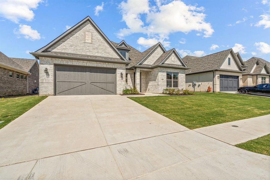 View of front of home featuring a front yard and a garage