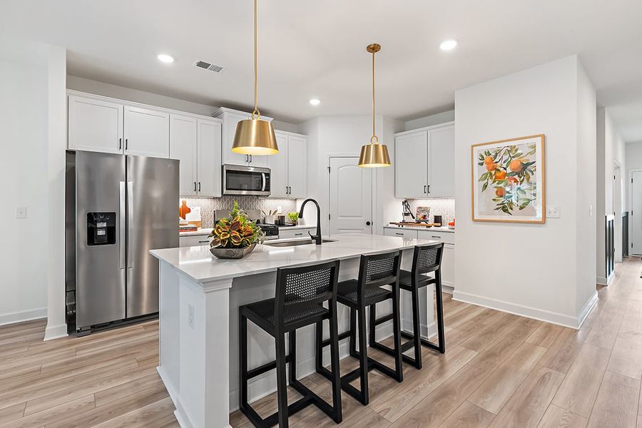 A kitchen with a dining table and a refrigerator. A kitchen with a dining table and a refrigerator.