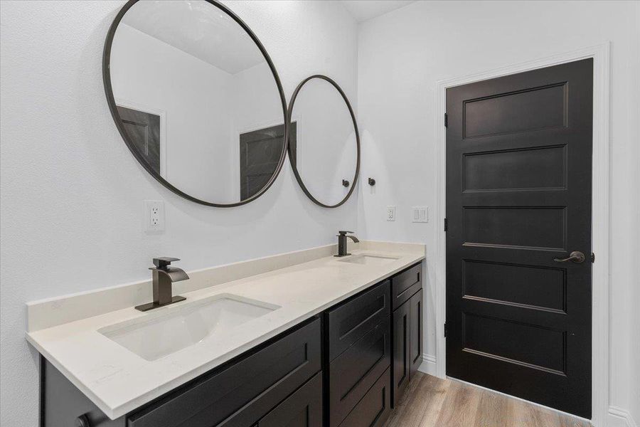 Full bathroom between 2 secondary bathrooms. Clean lines and a striking dark door define this modern bathroom with dual sinks. Full bathroom between 2 secondary bathrooms. Clean lines and a striking dark door define this modern bathroom with dual sinks.