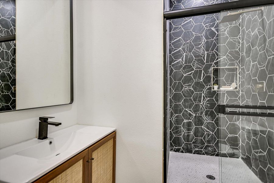 Full bath featuring vanity and tiled shower