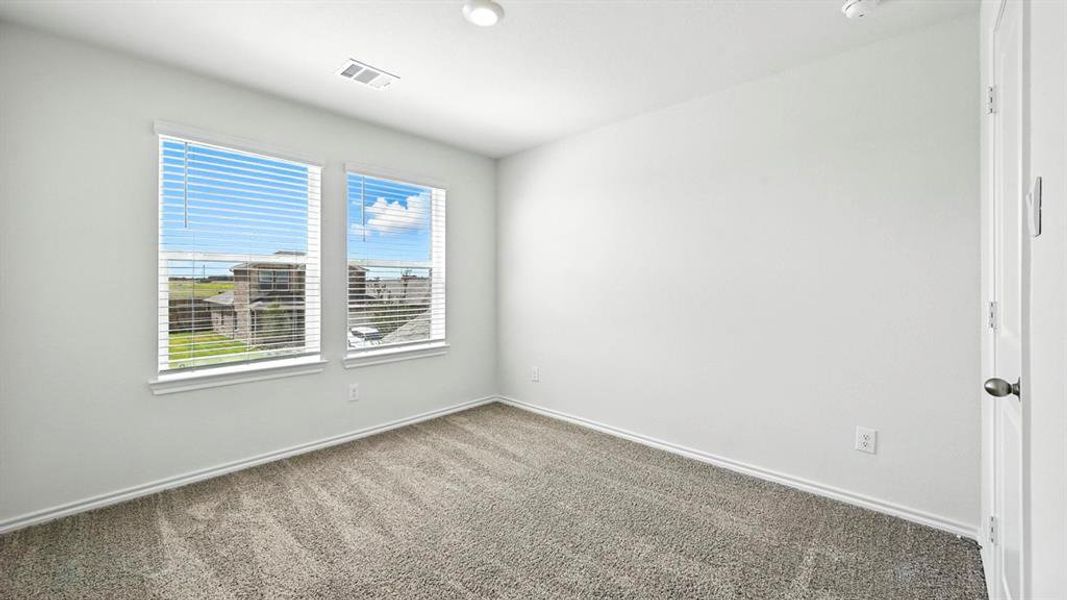 Carpeted room with two windows featuring blinds, white walls, and baseboards
