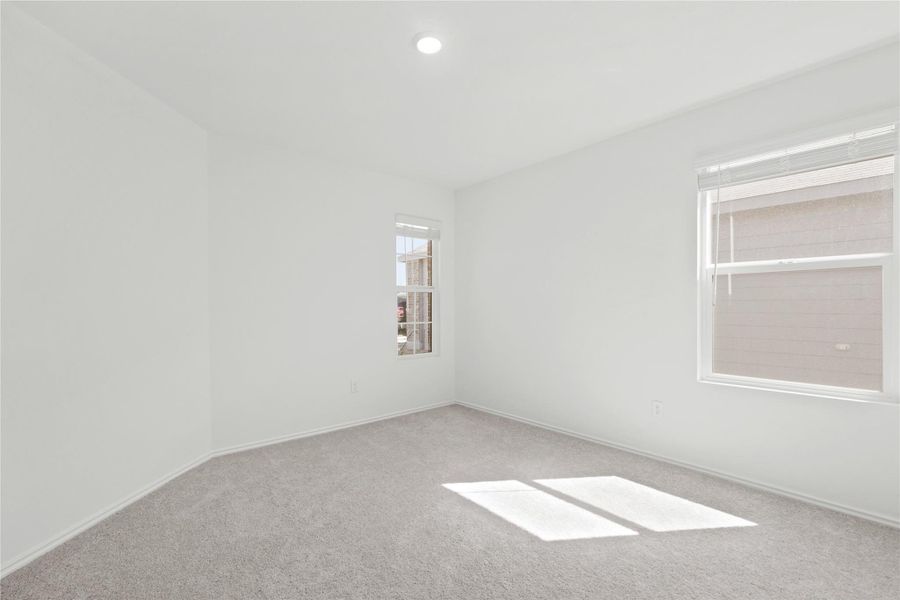 Spare room featuring light carpet and baseboards