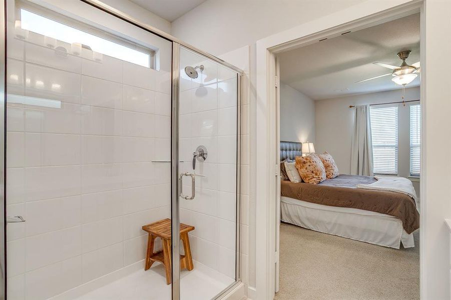 Ensuite bathroom with carpet, a stall shower, and a ceiling fan Ensuite bathroom with carpet, a stall shower, and a ceiling fan