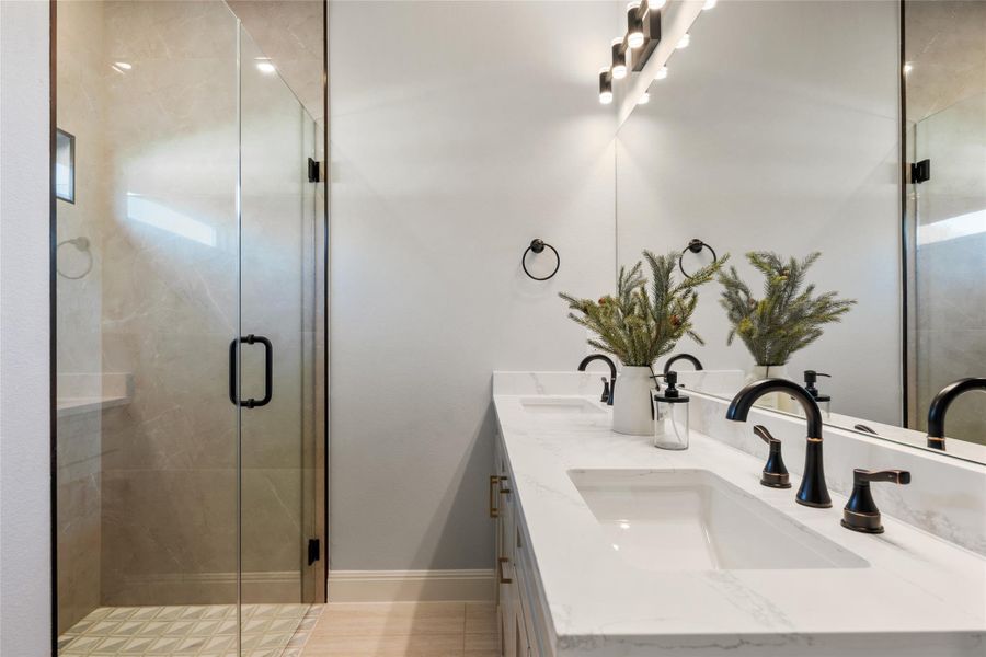 Full bath with a shower stall and double vanity