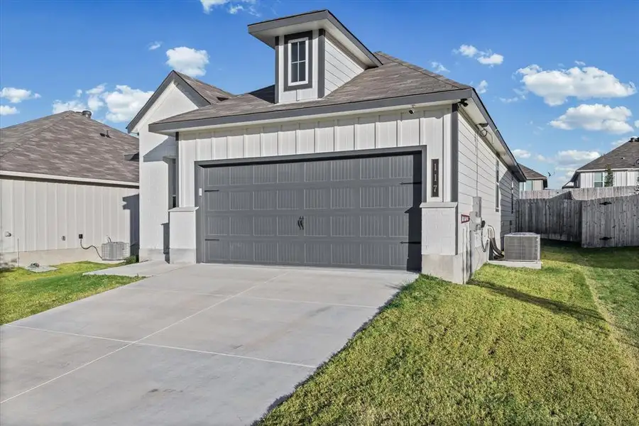 View of front facade with a shingled roof, board and batten siding, driveway, and an attached garage View of front facade with a shingled roof, board and batten siding, driveway, and an attached garage