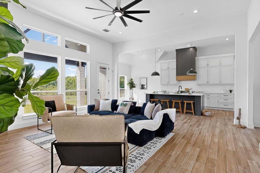 Living room featuring a ceiling fan, light wood-style flooring, and recessed lighting
