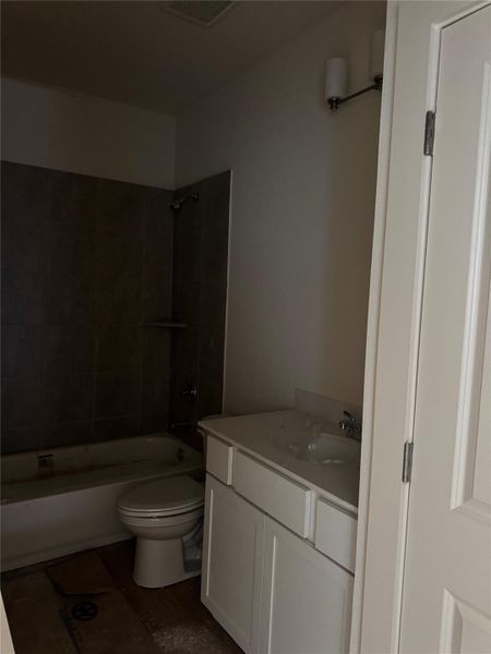Full bathroom featuring shower / bath combination, vanity, and dark tile patterned flooring