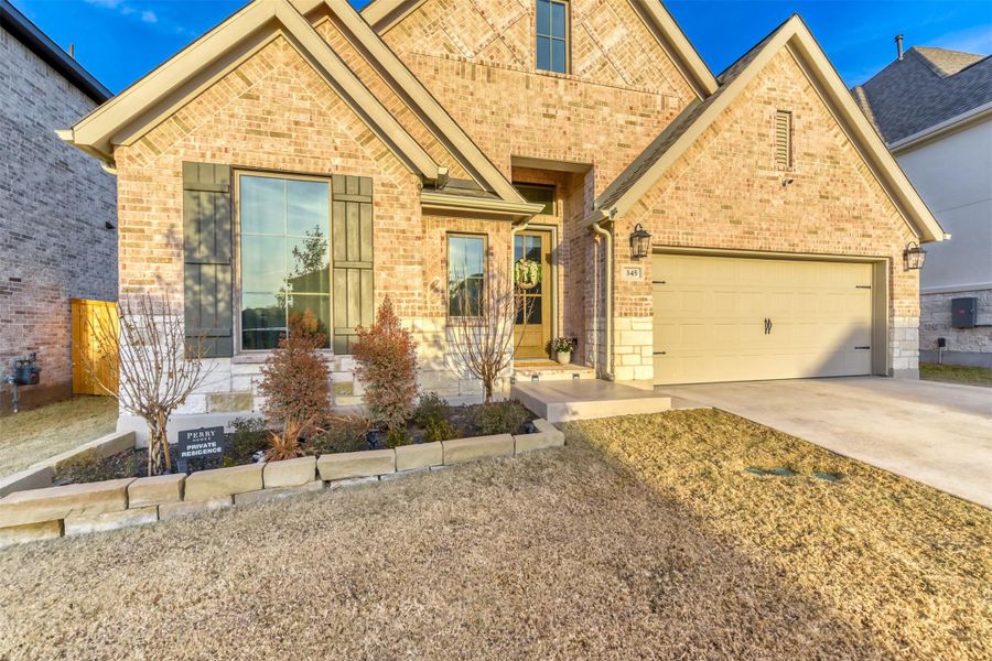 View of front of property with brick siding, concrete driveway, and a garage