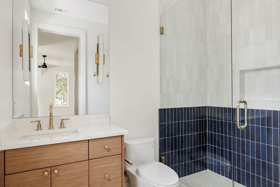 Playful yet refined, this secondary bath blends fresh navy tile with soft white finishes, an elevated nod to contemporary Austin style and craftsmanship. Playful yet refined, this secondary bath blends fresh navy tile with soft white finishes, an elevated nod to contemporary Austin style and craftsmanship.