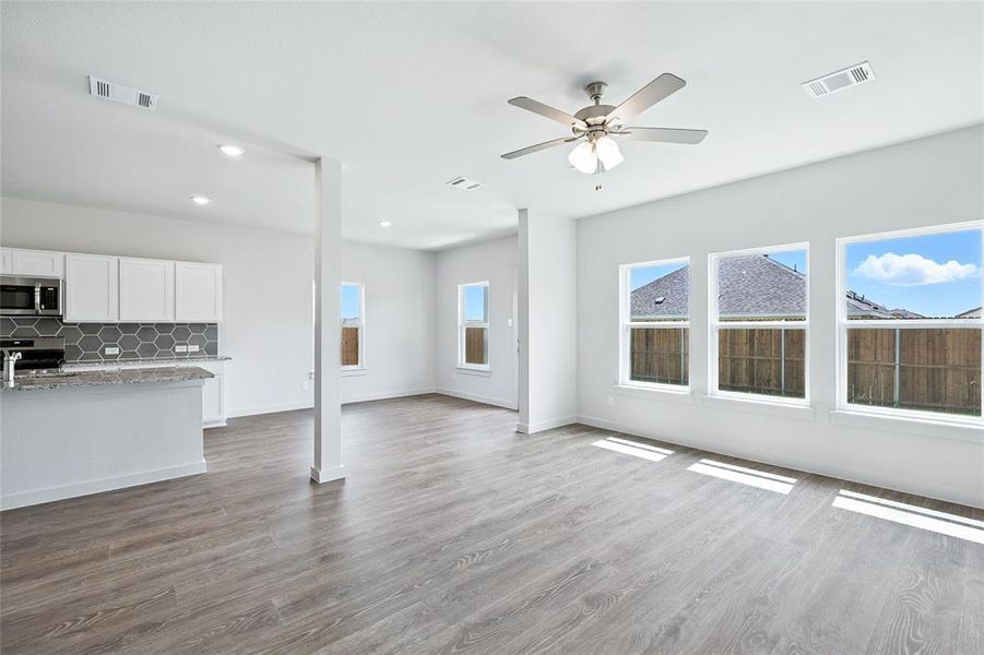 Unfurnished living room featuring dark wood-style flooring, ceiling fan, and recessed lighting Unfurnished living room featuring dark wood-style flooring, ceiling fan, and recessed lighting