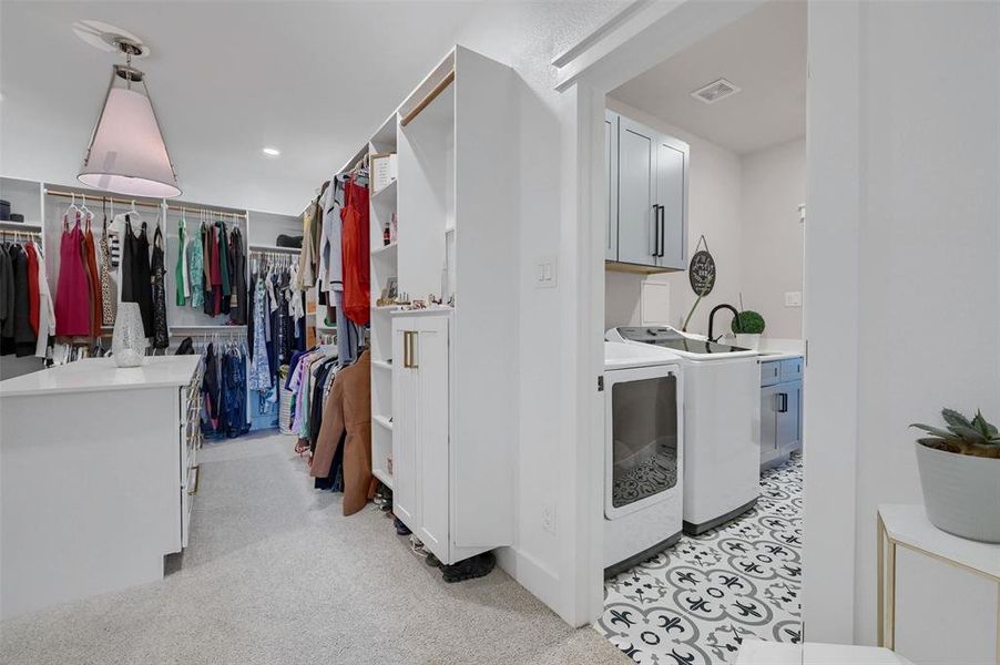 Laundry area with sink, separate washer and dryer, and cabinets