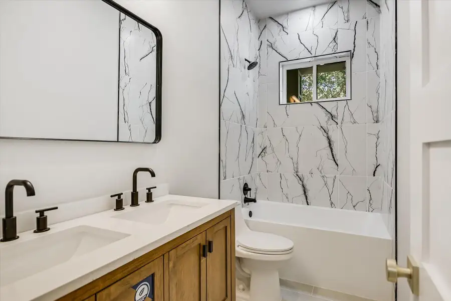 Full bath featuring double vanity and shower / bath combination