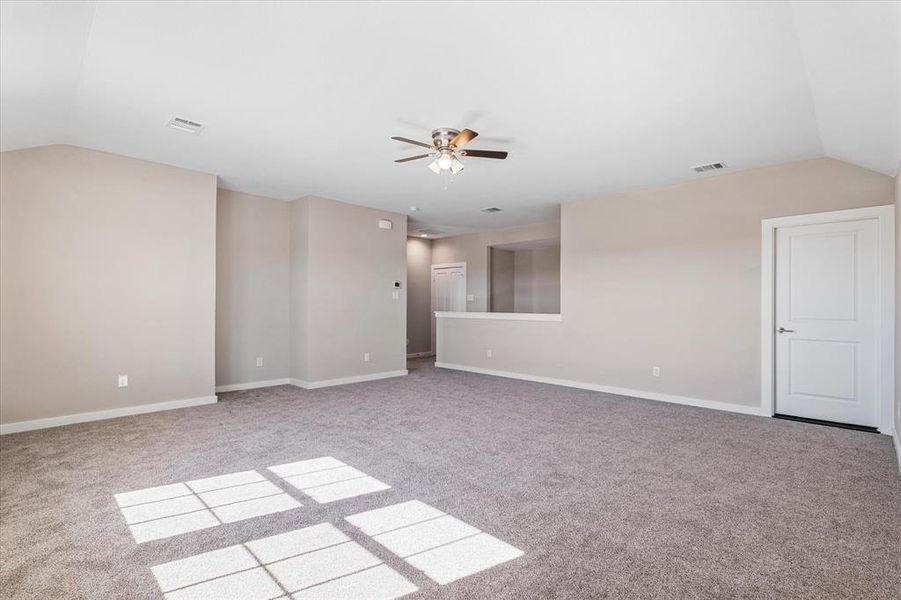 Bonus room with ceiling fan, light carpet, and vaulted ceiling Bonus room with ceiling fan, light carpet, and vaulted ceiling