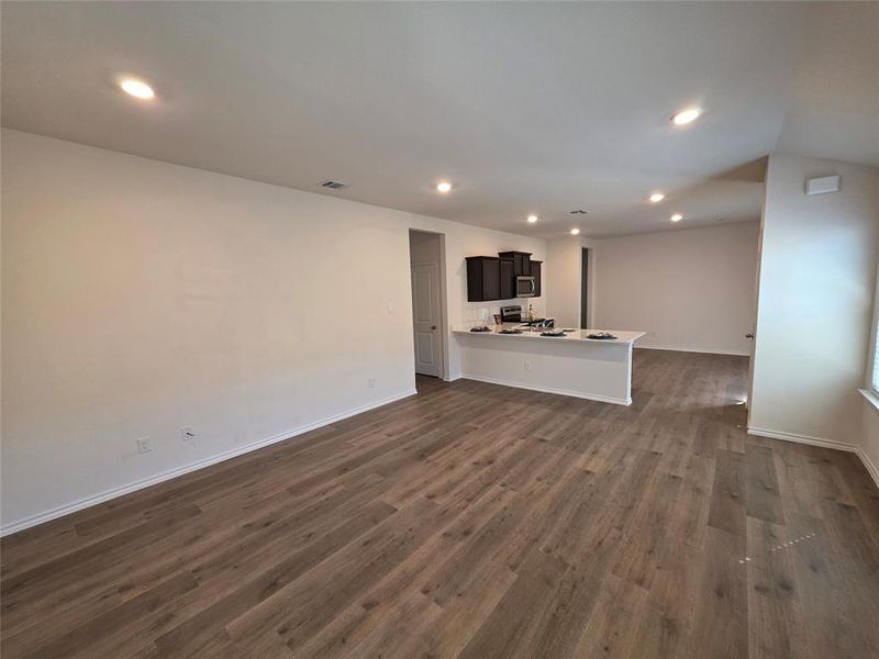 Unfurnished living room featuring recessed lighting and dark wood finished floors Unfurnished living room featuring recessed lighting and dark wood finished floors