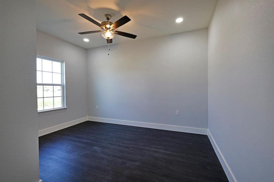 Unfurnished room featuring dark wood-type flooring, recessed lighting, and a ceiling fan Unfurnished room featuring dark wood-type flooring, recessed lighting, and a ceiling fan