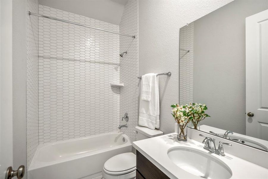 Elegant tiles, modern fixtures make this secondary bathroom a calming retreat.