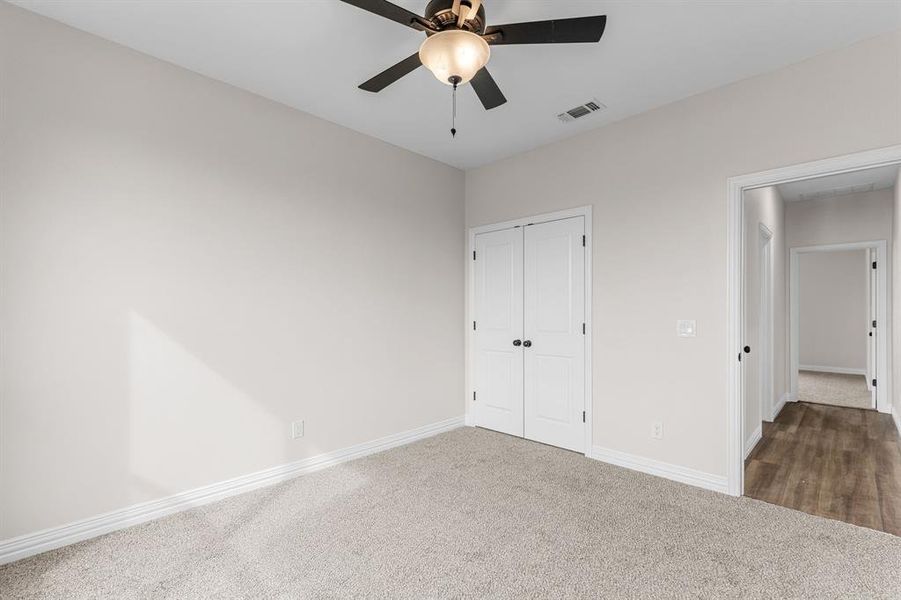 Unfurnished bedroom featuring dark carpet, a closet, and ceiling fan Unfurnished bedroom featuring dark carpet, a closet, and ceiling fan