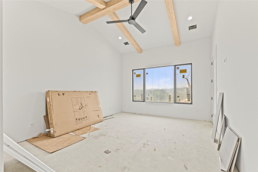 Vaulted ceiling with exposed wood beams and recessed lighting