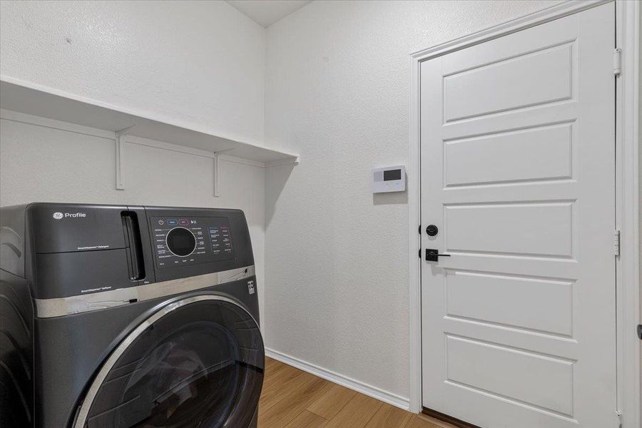 A well-organized laundry area offers a convenient space for chores with modern appliances and built-in shelving.
