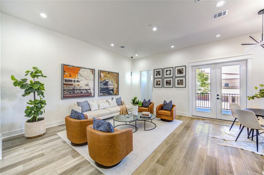 This bright and modern living area features a spacious layout with cozy living area and large windows that open to a balcony.