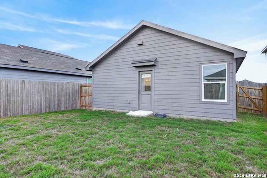 A well-maintained yard surrounds this neat rear exterior, enclosed by wood fencing for privacy. A well-maintained yard surrounds this neat rear exterior, enclosed by wood fencing for privacy.