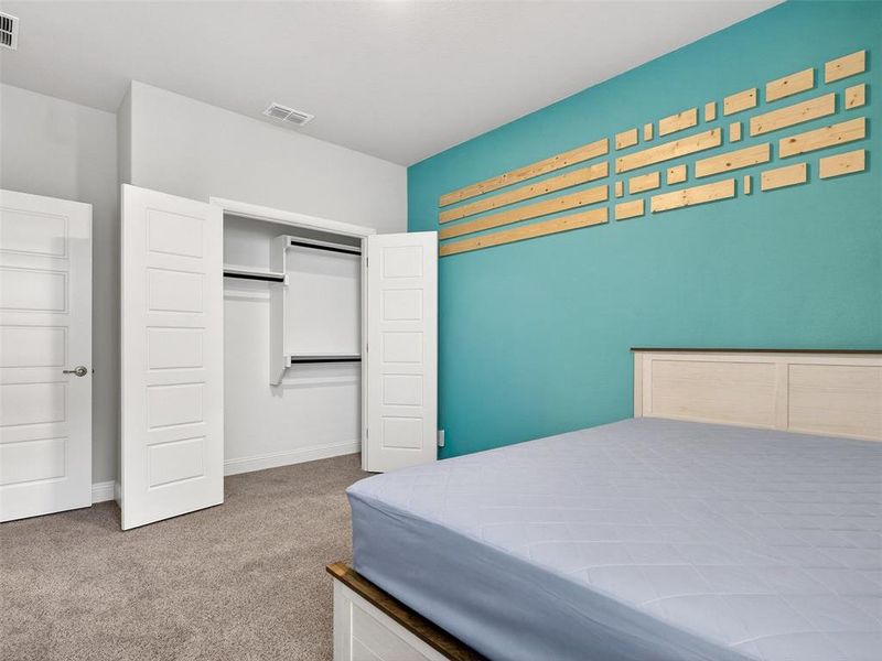 Plush grey carpeting and a built-in closet with shelving and hanging rods Plush grey carpeting and a built-in closet with shelving and hanging rods