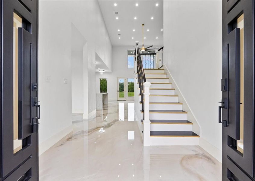 Grand two-story entry with dramatic ceilings and designer staircase.