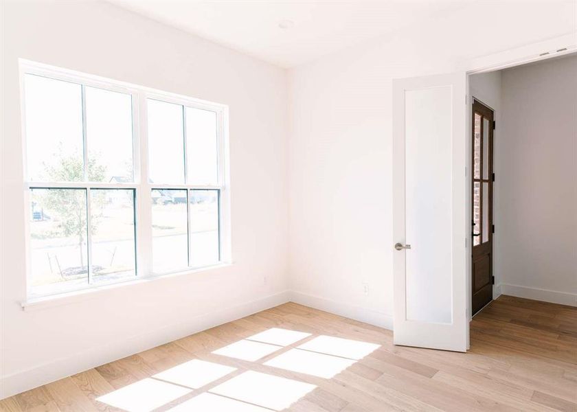 Empty room with light hardwood / wood-style flooring