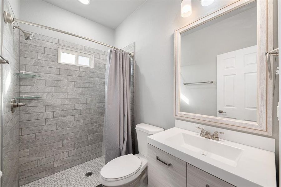 Bathroom with toilet, vanity, and walk in shower