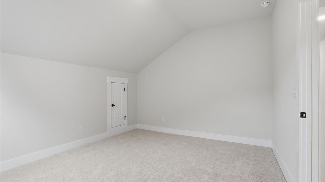 Accomplished bedroom layout with cozy carpet, a spacious walk-in closet, and sun-filled windows