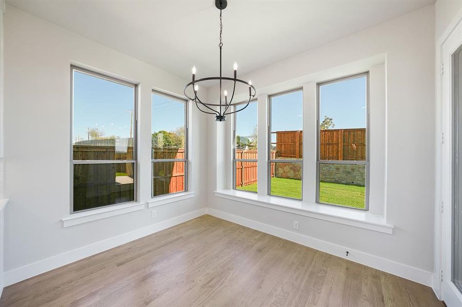 Unfurnished dining area with light wood-style floors and a chandelier Unfurnished dining area with light wood-style floors and a chandelier