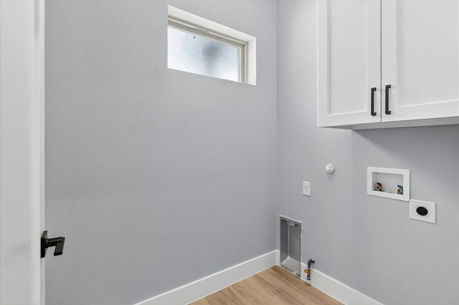 Functional utility space featuring light-colored walls and wood-finish flooring
