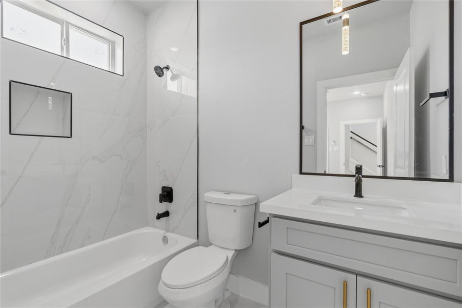 Modern full bath with sleek tile surround, matte black fixtures, and contemporary finishes.Thoughtfully designed with a tub/shower combo and bright, polished appeal.