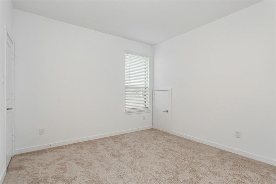 2nd floor bedroom 2 with Jack and Jill bath. Private sink area. Neutral-toned carpeting and white walls define this interior space